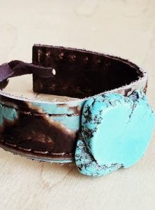 bracelet with turquoise and brown leather wrist band and a round turquoise stone in the center
