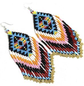  A pair of handmade beaded earrings with a diamond-shaped design. The center of each earring features a geometric pattern in blue, black, red, yellow, and white beads. Extending from the diamond shape is a cascading fringe with colors transitioning through black, red, pink, orange, yellow, white, and light blue. The ends of the fringe are finished with small gold beads. The earrings are attached to fishhook-style ear wires for wearing.